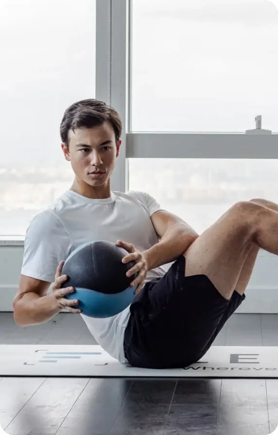 man performing a russian twist with a medicine ball